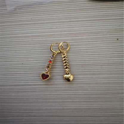 Women's gold and silver heart-shaped alloy drop earrings on a plain background.