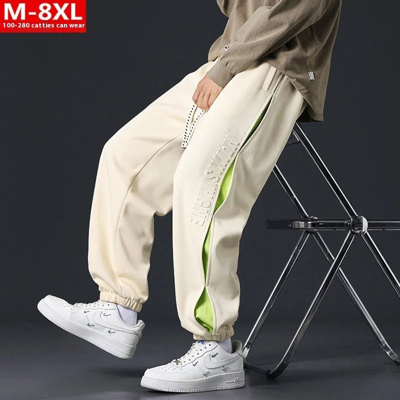 Men's ankle banded trousers in micro-elastic cotton with collage stitching details, showing loose fit and tapered leg