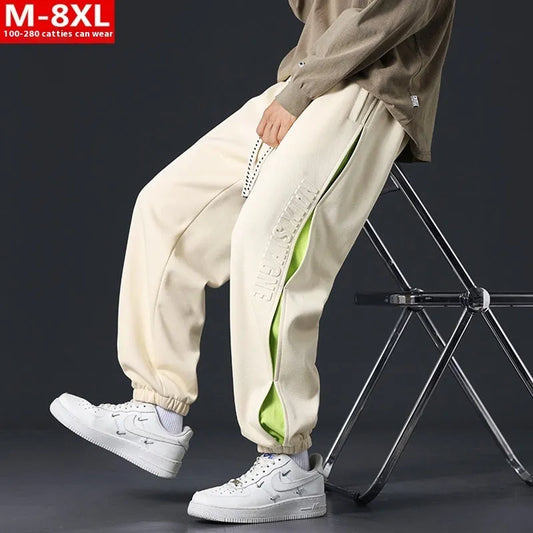 Men's ankle banded trousers in micro-elastic cotton with collage stitching details, showing loose fit and tapered leg