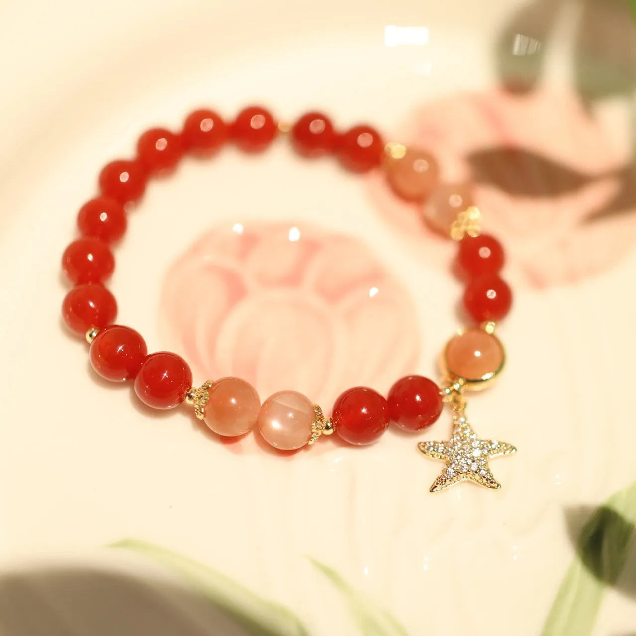 Women's handmade red agate and sunstone bracelet with ethnic charms