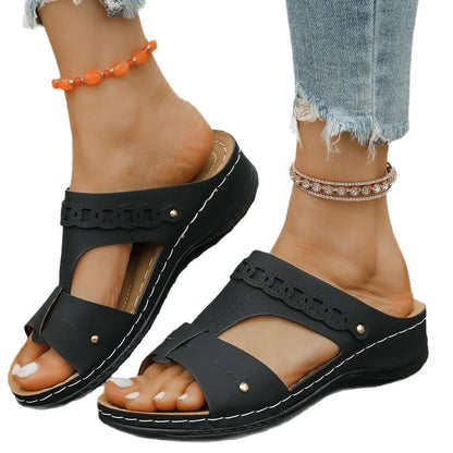 Blue roman style slippers with a slope heel and fish mouth toe holder on a wooden floor.