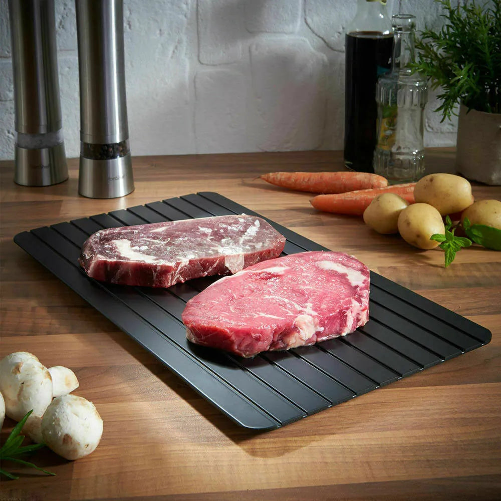 Black aluminium fast defrosting tray for thawing frozen food on kitchen counter