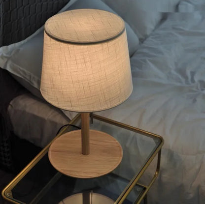 Walnut solid wood bedside lamp with fabric lampshade on wooden surface