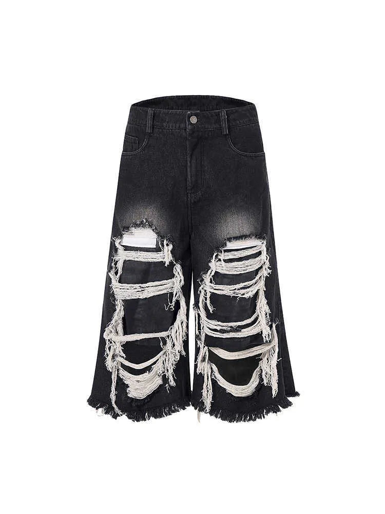Black cropped wide-leg jeans with a mid-high waist, ripped patch detail, and a loose fit on a model.