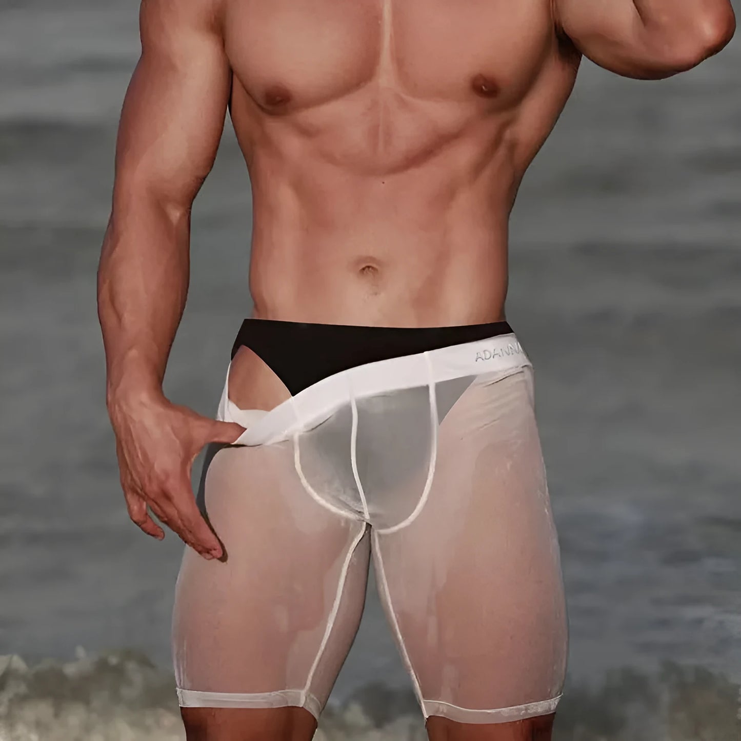 Fashion Personality men's black seamless mesh lounge shorts on a hanger, showing hip-lift design and knitted texture.