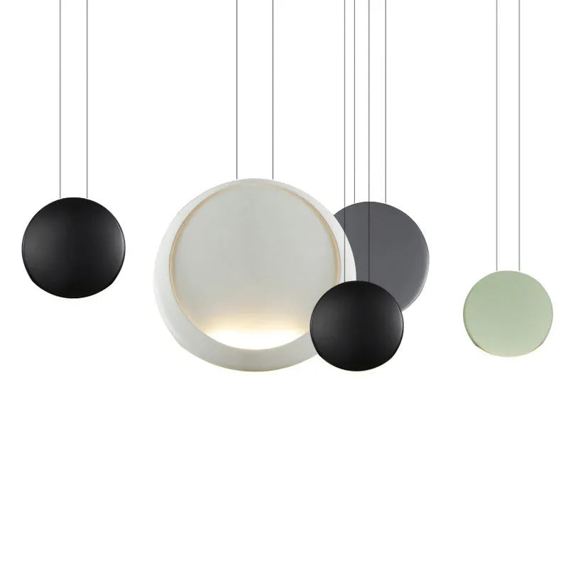 Round resin cosmos chandelier light with adjustable hanging height, shown in a bedroom setting.