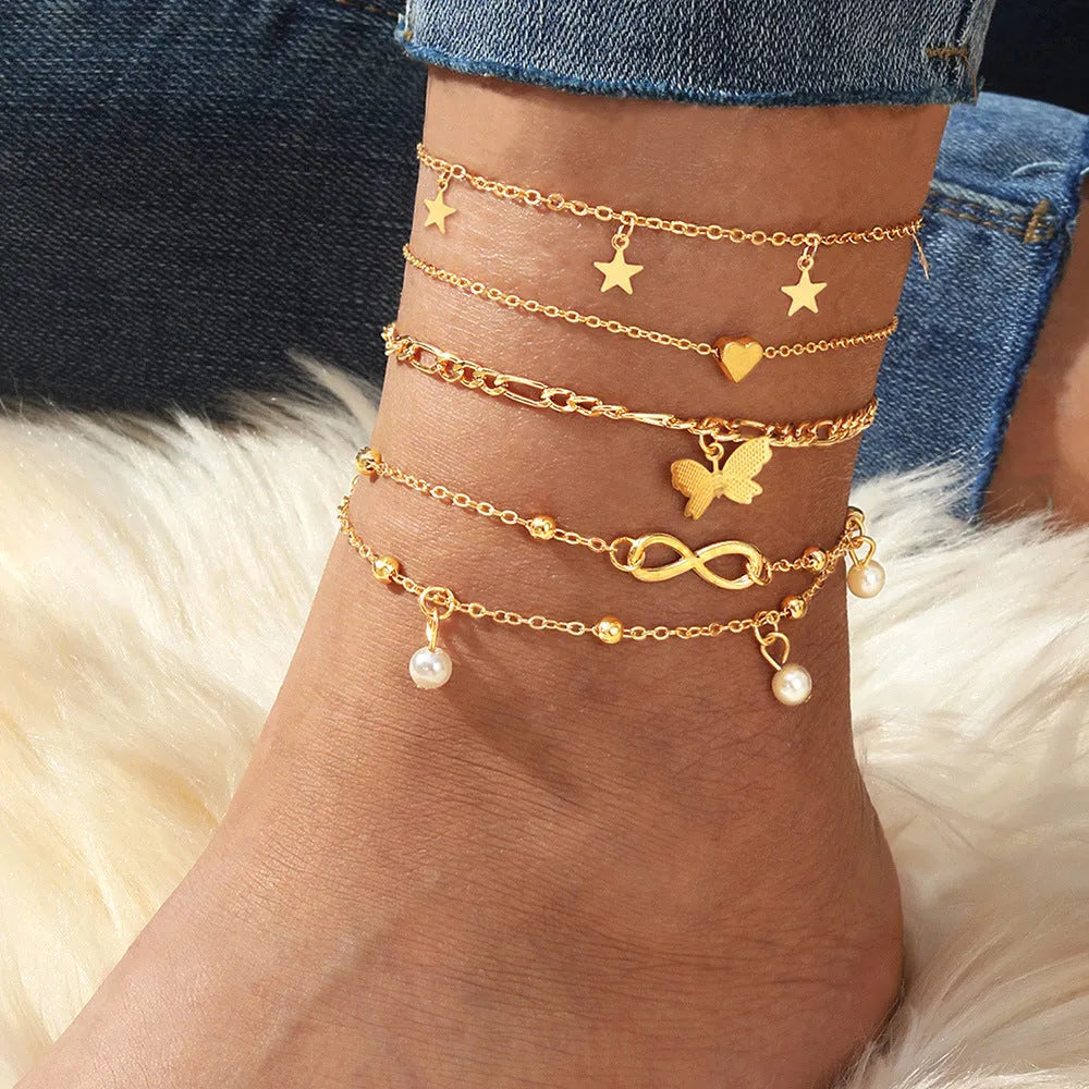 Four-piece women's anklet set with butterfly, pearl, and heart designs in alloy metal