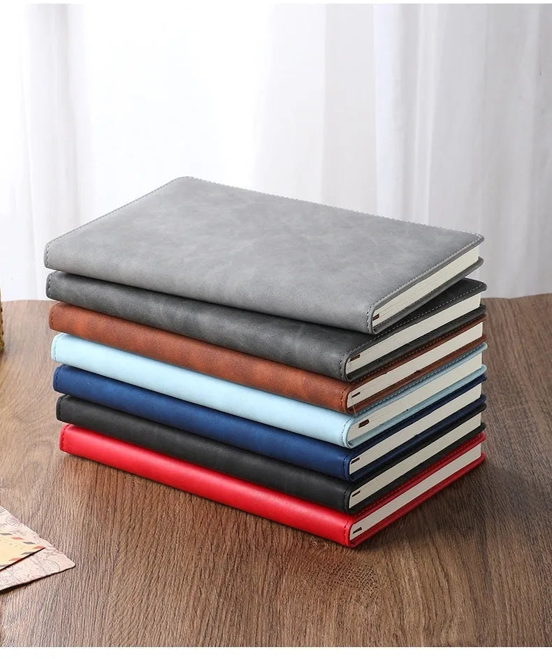 A5 notebook with imitation leather cover in a choice of colours including black, red, green, blue, and orange.