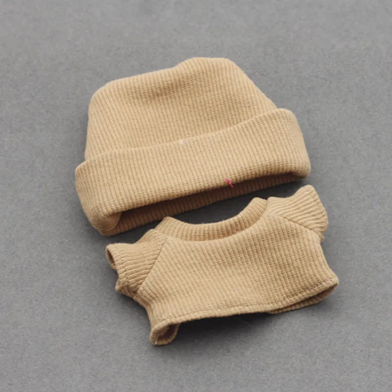 Doll clothes set with knitted flanging hat and T-shirt in multiple colours including pink, white, and stripes.