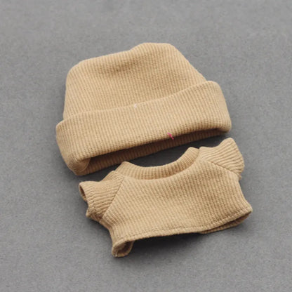 Doll clothes set with knitted flanging hat and T-shirt in multiple colours including pink, white, and stripes.