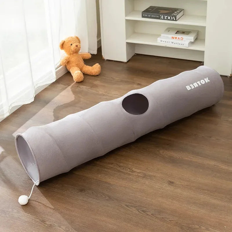 Collapsible brown or grey cat tunnel with a plush ball on top, shown in both extended and folded flat positions.