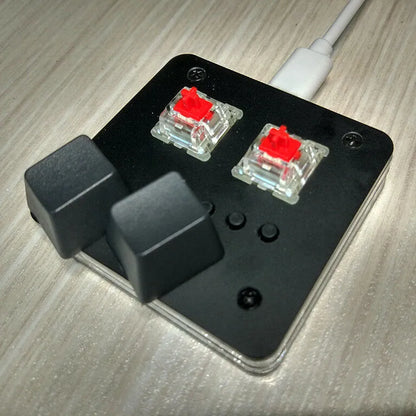 Mini white plastic USB wired keyboard with multimedia keys on a desk.
