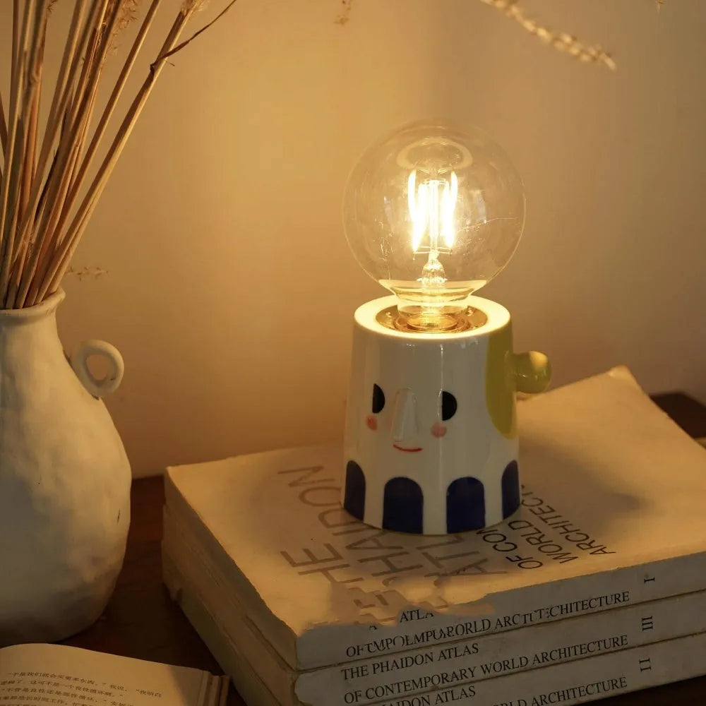 Handmade ceramic lamp with ball headlight design on a bedside table