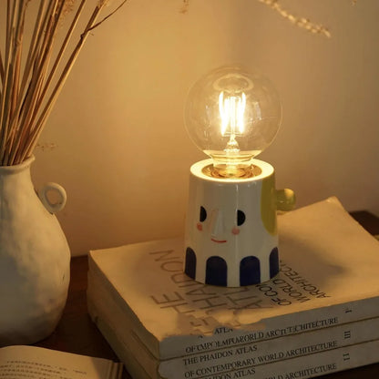 Handmade ceramic lamp with ball headlight design on a bedside table