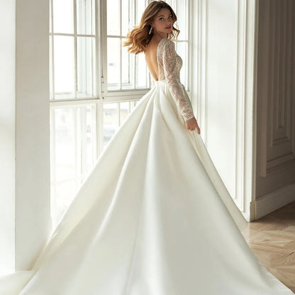 White long-sleeved mid-waist dress with gilded hollow-out detailing, shown in full length.