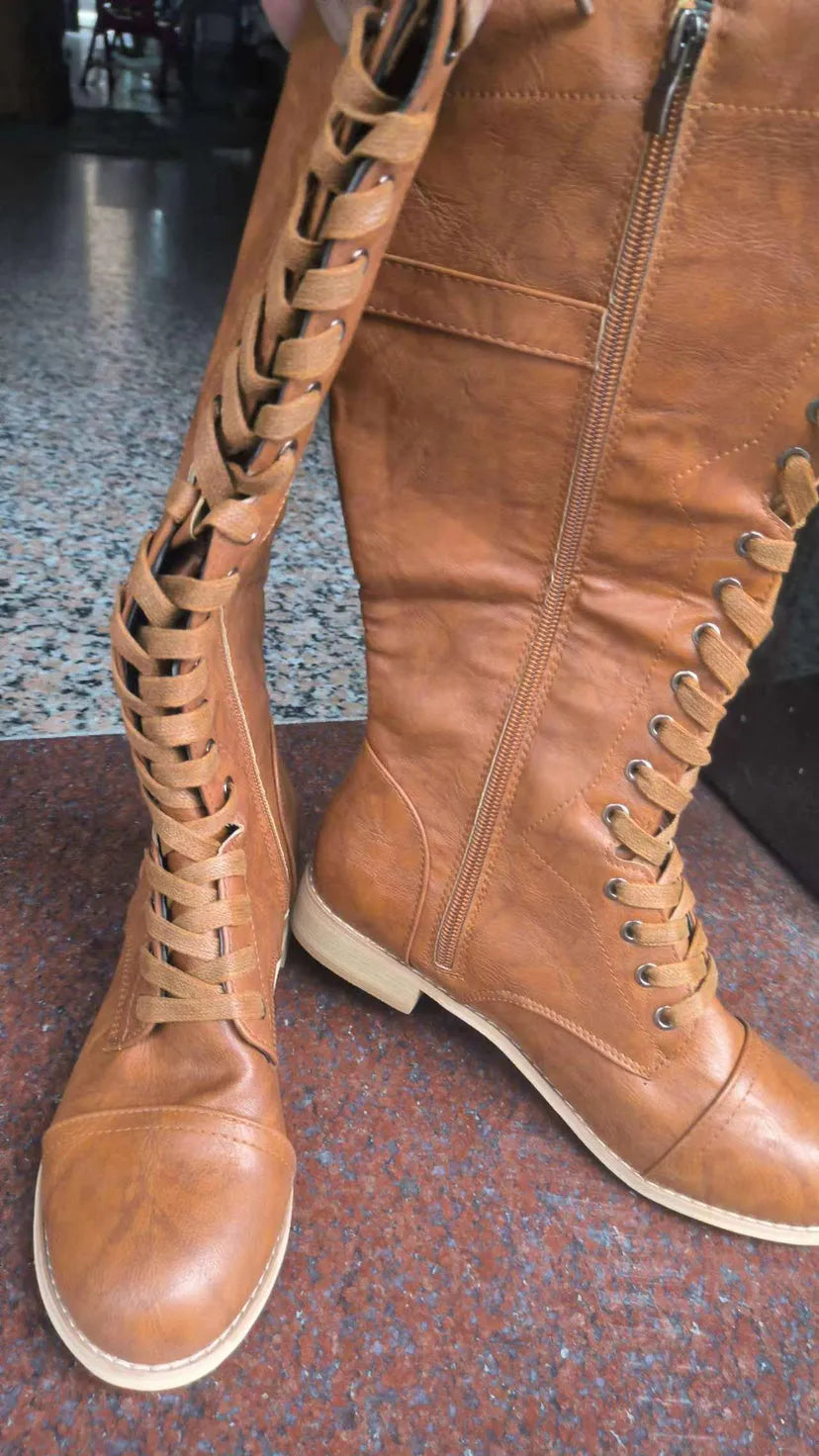 Women's black knight ankle boots with a cross strap fastening detail.