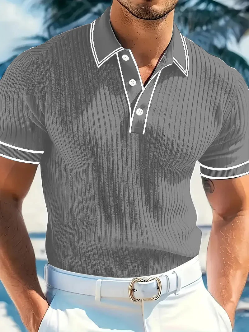 A man wearing a loose-fit, striped, short-sleeved polo shirt in a dark colour.