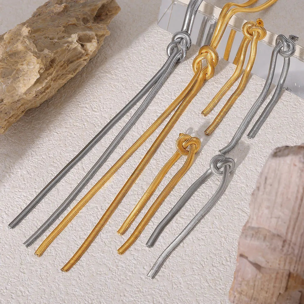 Gold electroplated titanium steel knotted tassel necklace and matching earrings set on a white background.