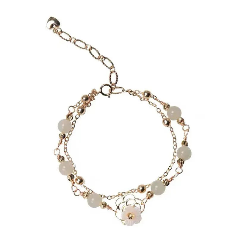 Women's shell flower butterfly bracelet in yellow gold with geometric design and hetian jade style charm.