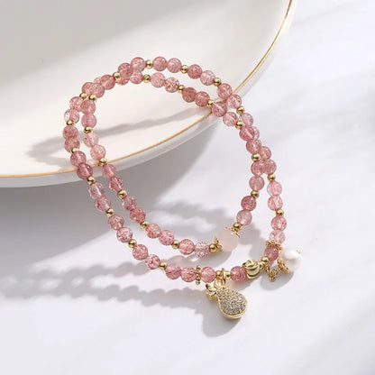 Women's geometric strawberry quartz crystal bracelet with a silver wallet money charm.