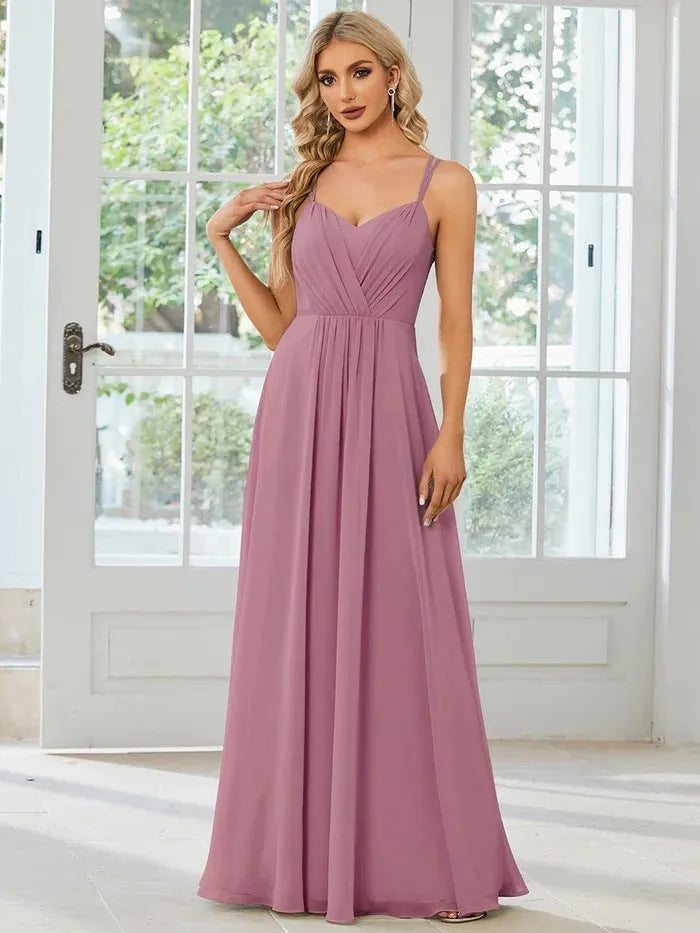 Women's sleeveless long dress with sling neckline and pleated A-line skirt in a solid colour.