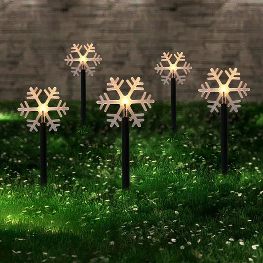 Snowflake-shaped garden lights with warm, soft glow illuminating an outdoor garden or patio area