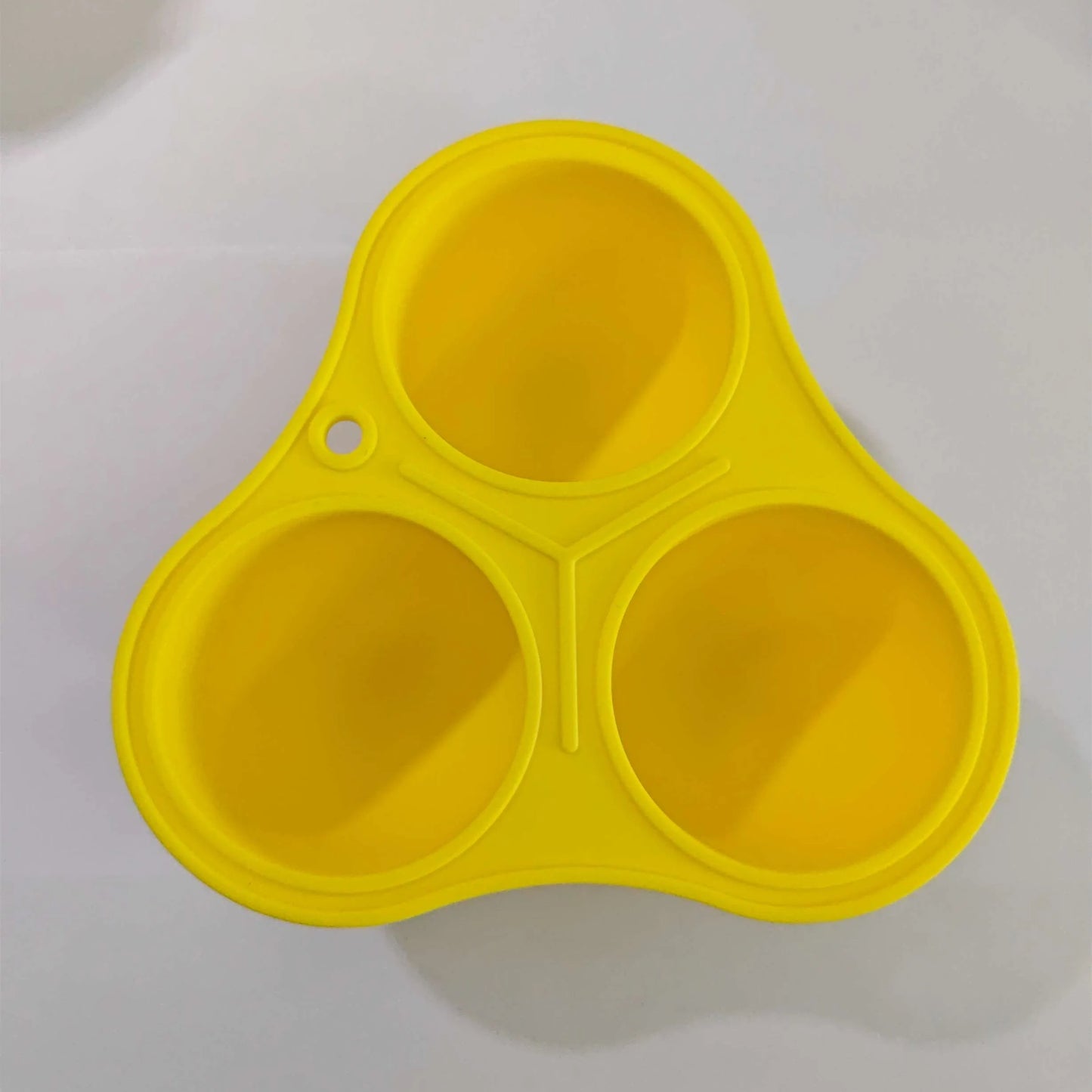 Yellow silicone pet slow feed ball with dental cleaning grooves and removable snack mold accessory