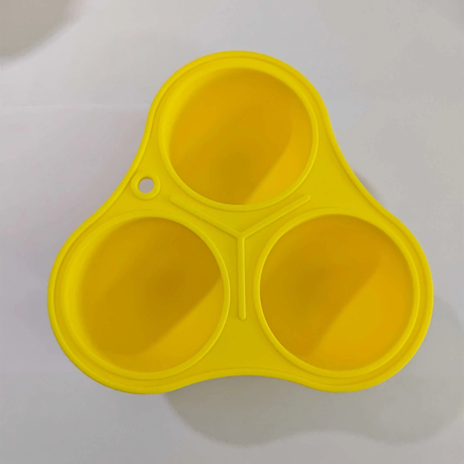 Yellow silicone pet slow feed ball with dental cleaning grooves and removable snack mold accessory