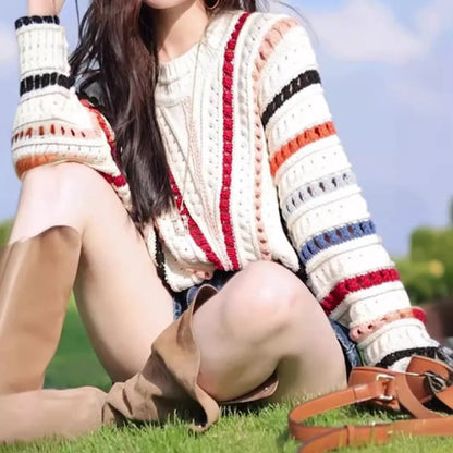 Rainbow striped batwing sleeve hollow knit sweater with round neck, shown in loose fit on model
