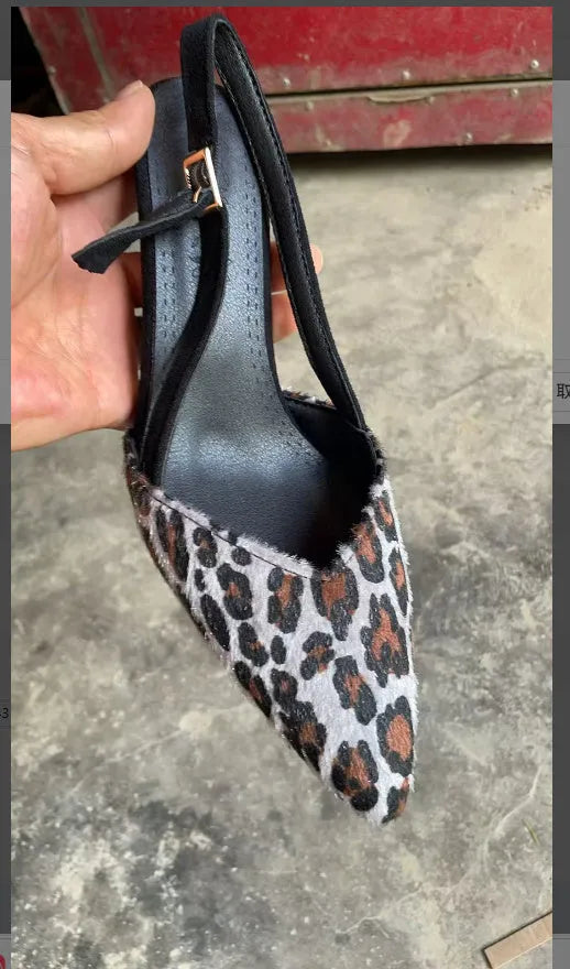 Leopard print suede women's sandals with a pointed toe high heel on a neutral background.
