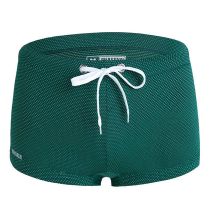 Men's low waist boxer style swimming trunks in nylon, available in multiple solid colours.