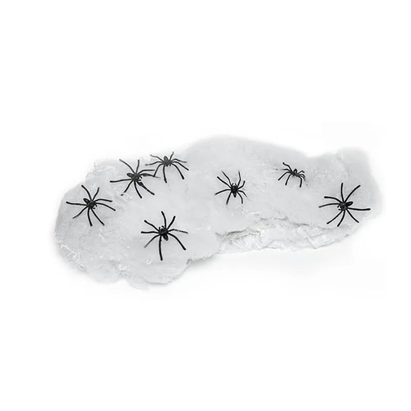 White cotton spider web Halloween decoration with multiple spiders draped over furniture for spooky atmospheric display