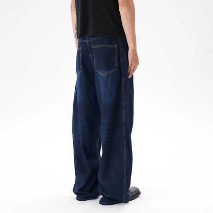 Woman wearing dark blue distressed wide leg denim jeans in a casual setting.
