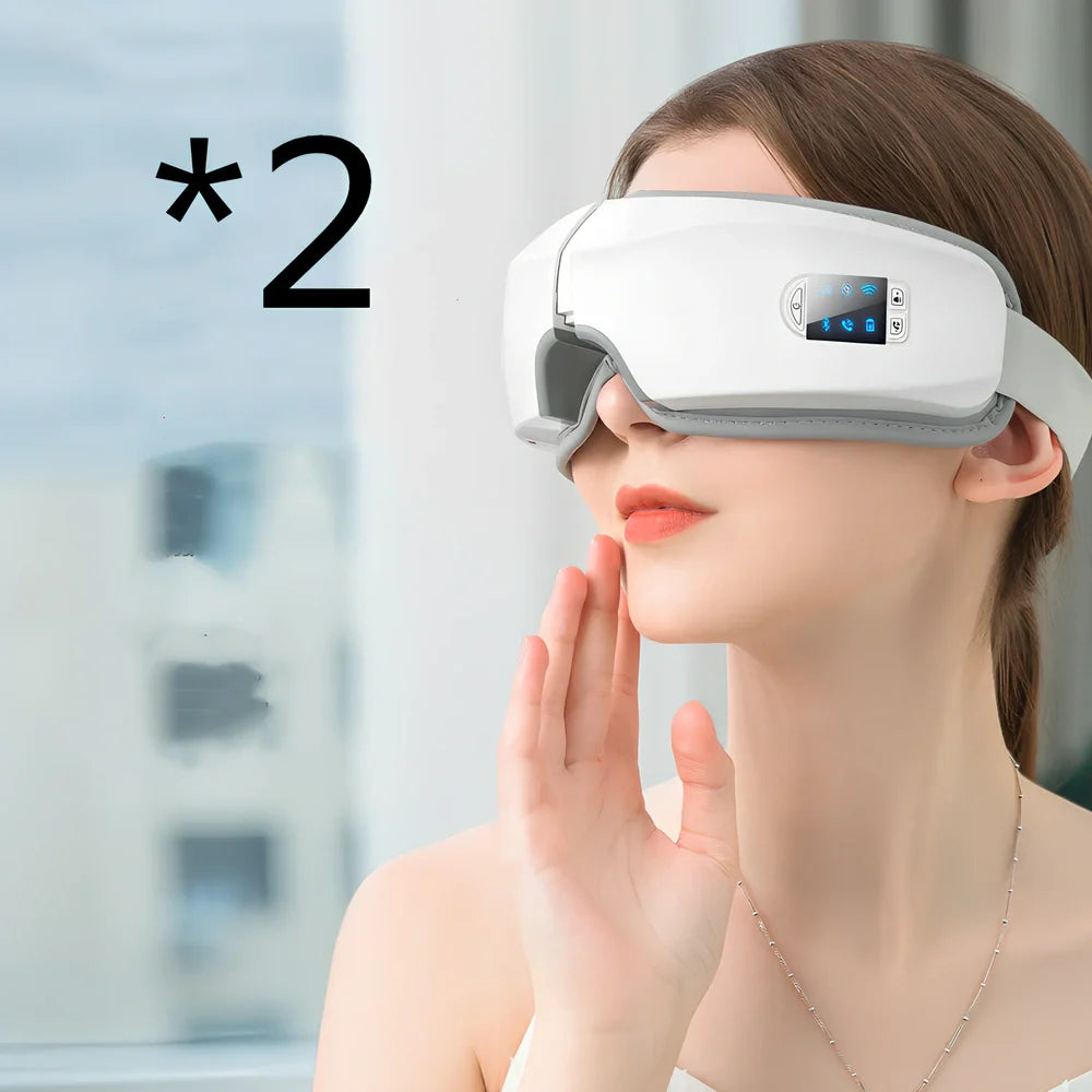 White folding eye massager device with LCD screen, shown in open and closed positions