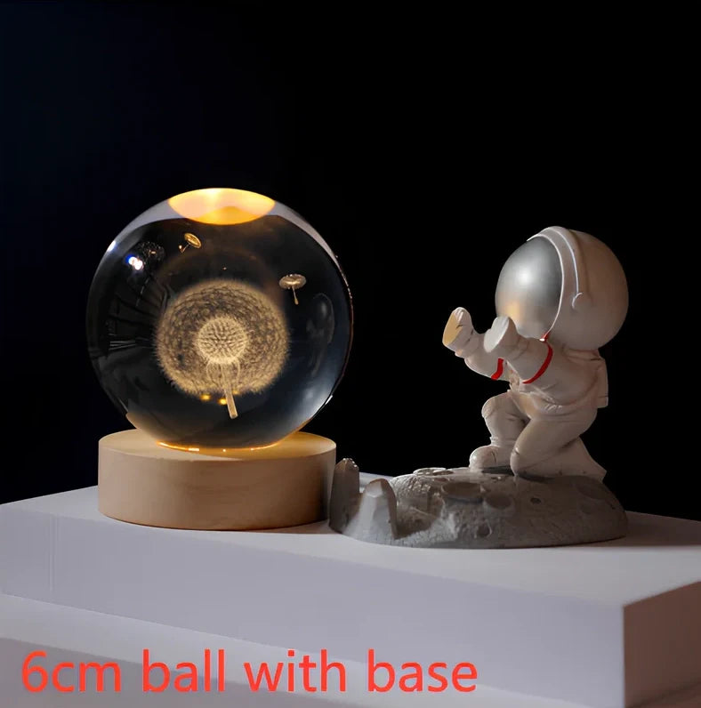 3D crystal ball night light projecting solar system pattern on wooden base with astronaut figurine