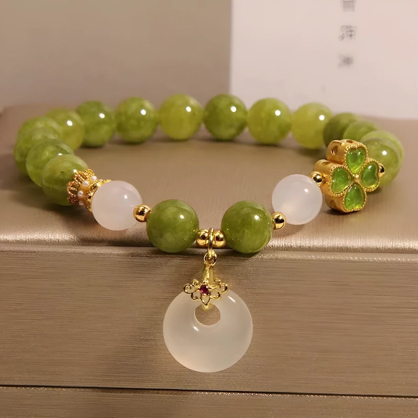 Green tourmaline women's bracelet with four-leaf clover safety buckle and geometric drop shape.