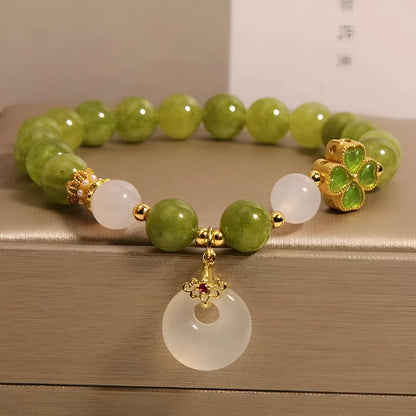 Green tourmaline women's bracelet with four-leaf clover safety buckle and geometric drop shape.