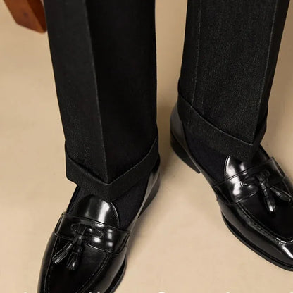 Men's black genuine leather tassel loafers with a rubber sole, shown from a side angle.