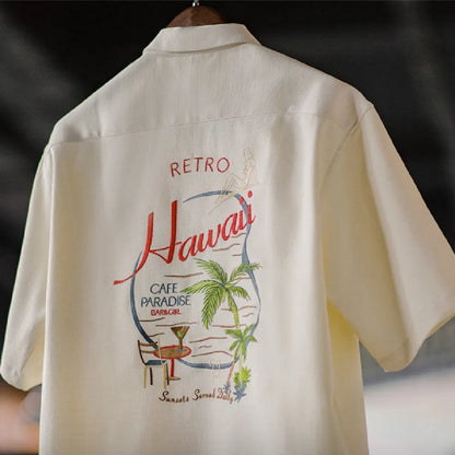 Light apricot men's shirt with a bamboo plant pattern and a Cuban collar laid flat.