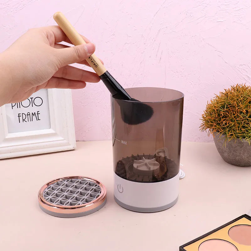 Grey and white portable electric makeup brush cleaner with USB charging cable.