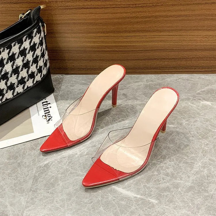 Women's black ultra-high vamp stiletto heel slippers with a pointed toe on a plain background.