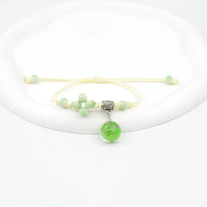 Hand-woven glass bracelet with large 1.4 cm beads containing real dried flowers, shown in blue.