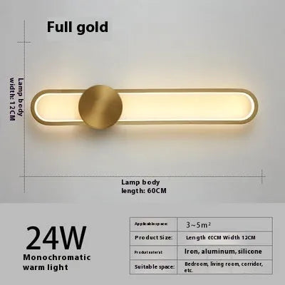 Round black iron wall sconce with integrated LED light glowing on a modern grey wall