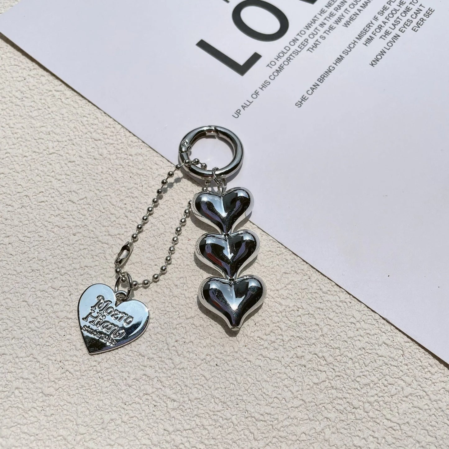 Acrylic key ring with an electroplated decorative charm in a choice of heart, bell, or water drop shapes.