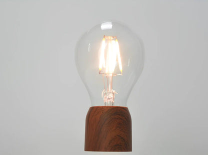 Magnetic levitation bulb floating above imitation wood base with international plug options