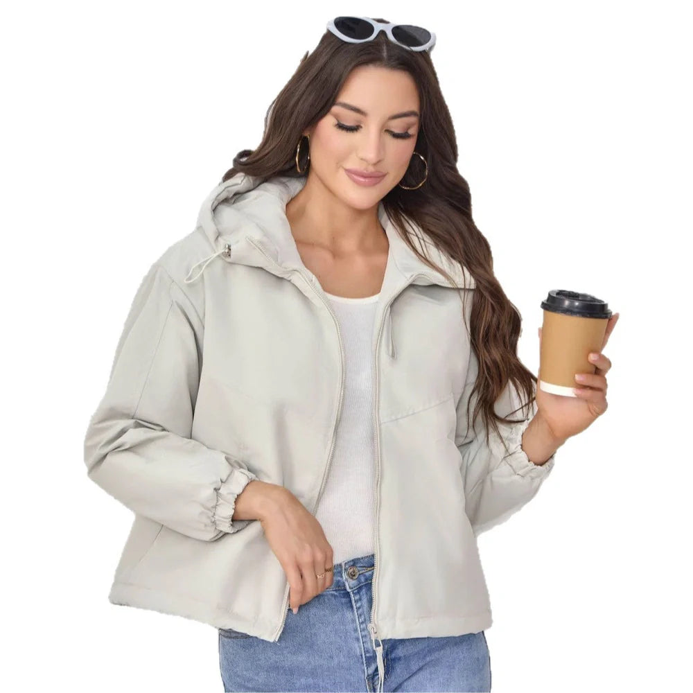 Women's grey hooded shell jacket with loose fit and long sleeves on hanger