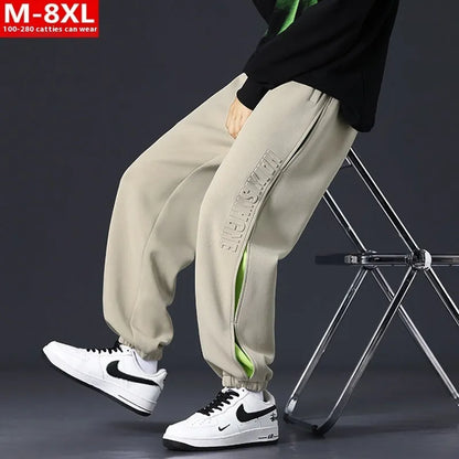 Men's ankle banded trousers in micro-elastic cotton with collage stitching details, showing loose fit and tapered leg