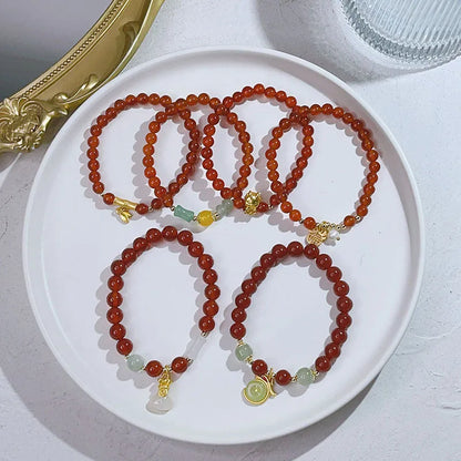 Close-up of a red agate bracelet featuring a detailed dragon design in a Chinese style.