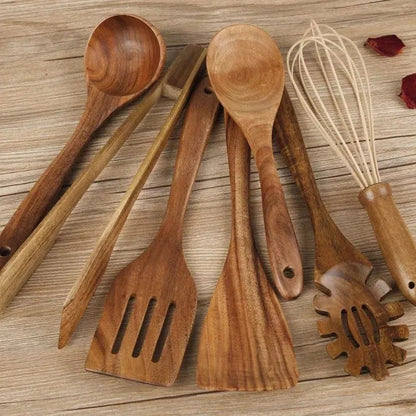 Set of seven light brown wooden cooking utensils including spoons, spatula, and turner on a kitchen counter.
