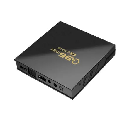 Q96 MAX Android TV set-top box with remote control and HDMI cable on a wooden surface.